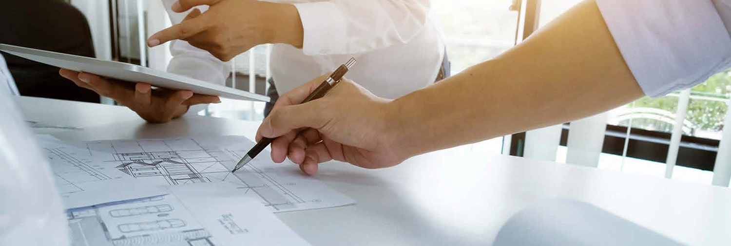 arquitectos técnicos revisando planos para proyecto de rehabilitación